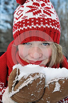 Beautiful blond girl in red cap and scarf.Traditional Â  Christmas decorative knitted pattern in Scandinavian style